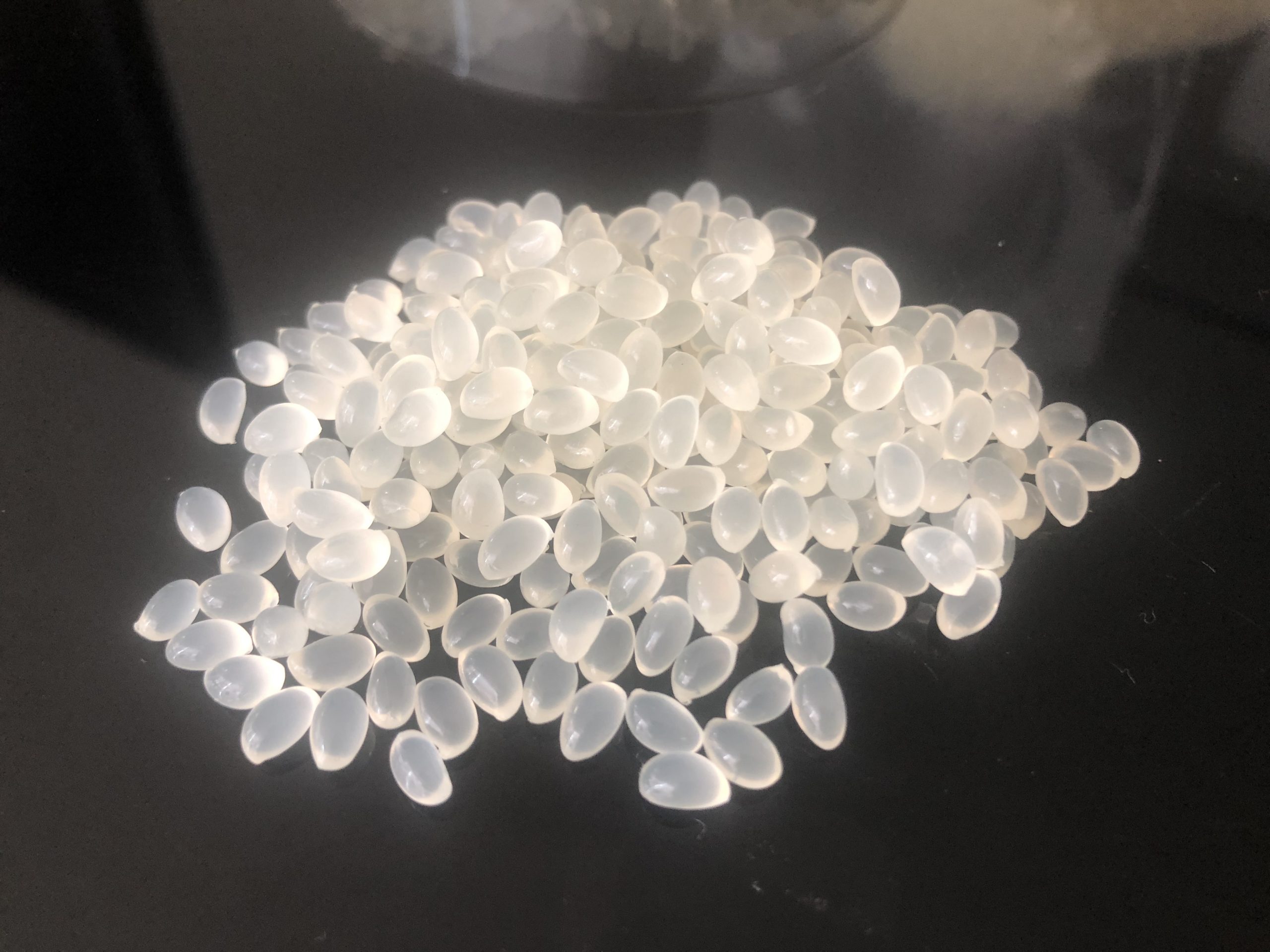 Why do hot melt adhesive particles produce smoke during the heating process?